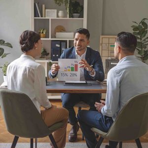two-men-sit-table-with-sign-that-says-we-re-it-scaled (1)